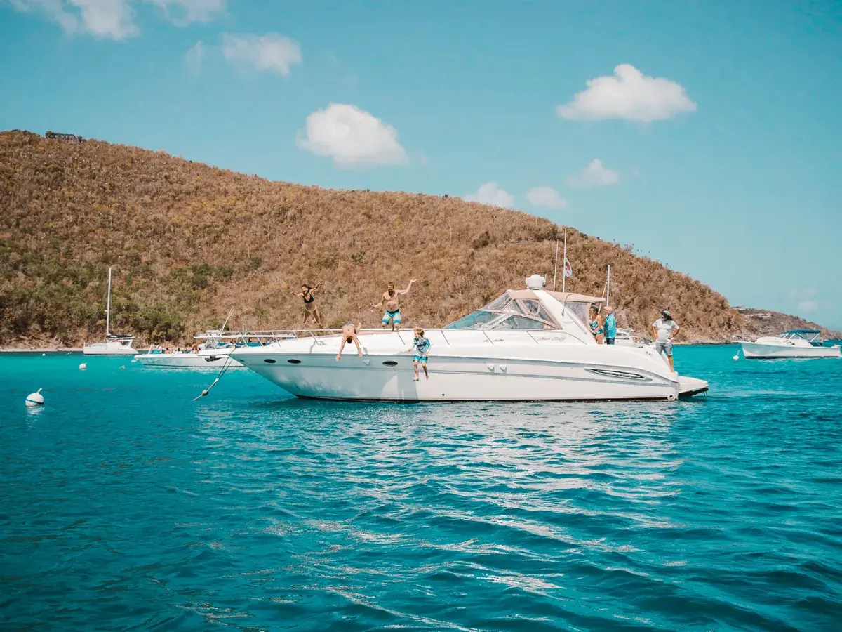 Family jumping off a yacht into turquoise Caribbean water — Stormy Pirates Boat Charters, USVI