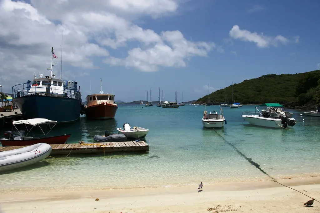 Boats tied at a Virgin Islands dock with green hillsides and calm water behind