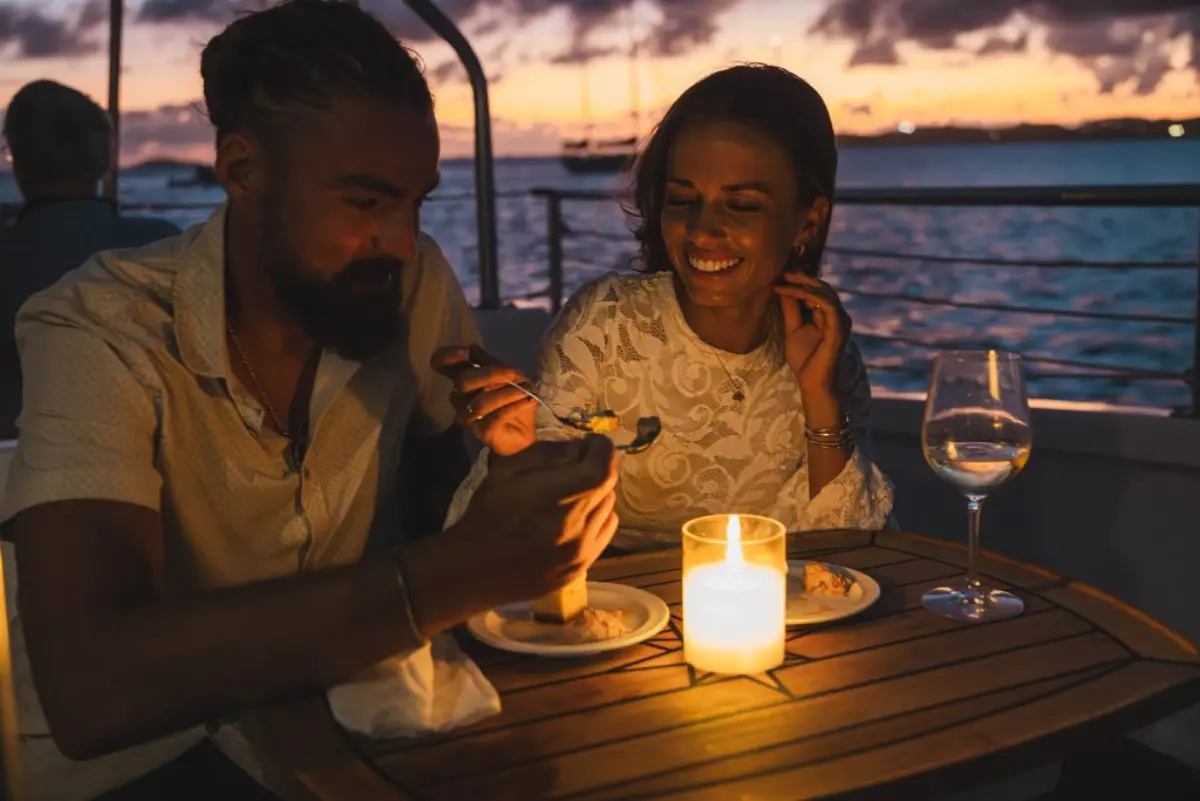 Couple enjoying a candlelit dinner on a boat at sunset in St. John, USVI with Caribbean sky views