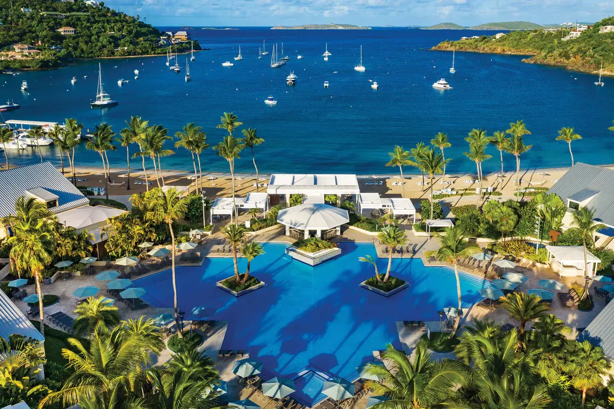Aerial view of The Westin St. John resort pool, beach, and Great Cruz Bay with sailboats anchored in turquoise waters