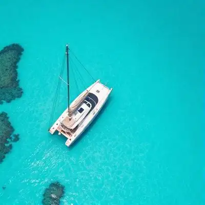Aerial view of catamaran sailing through crystal-clear Caribbean waters near USVI